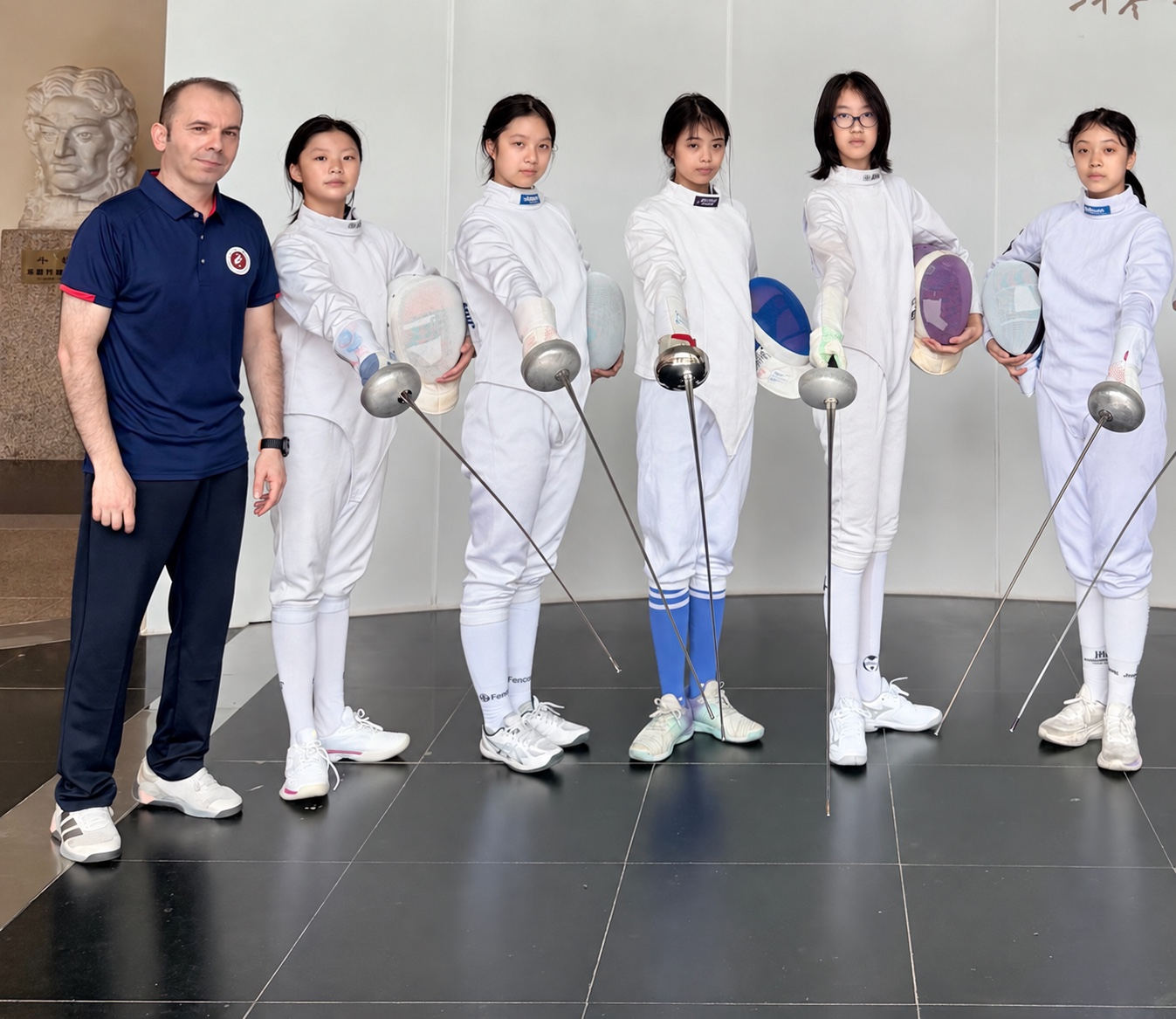 Coach Yousef Alaghehband with young fencers in a school fencing program