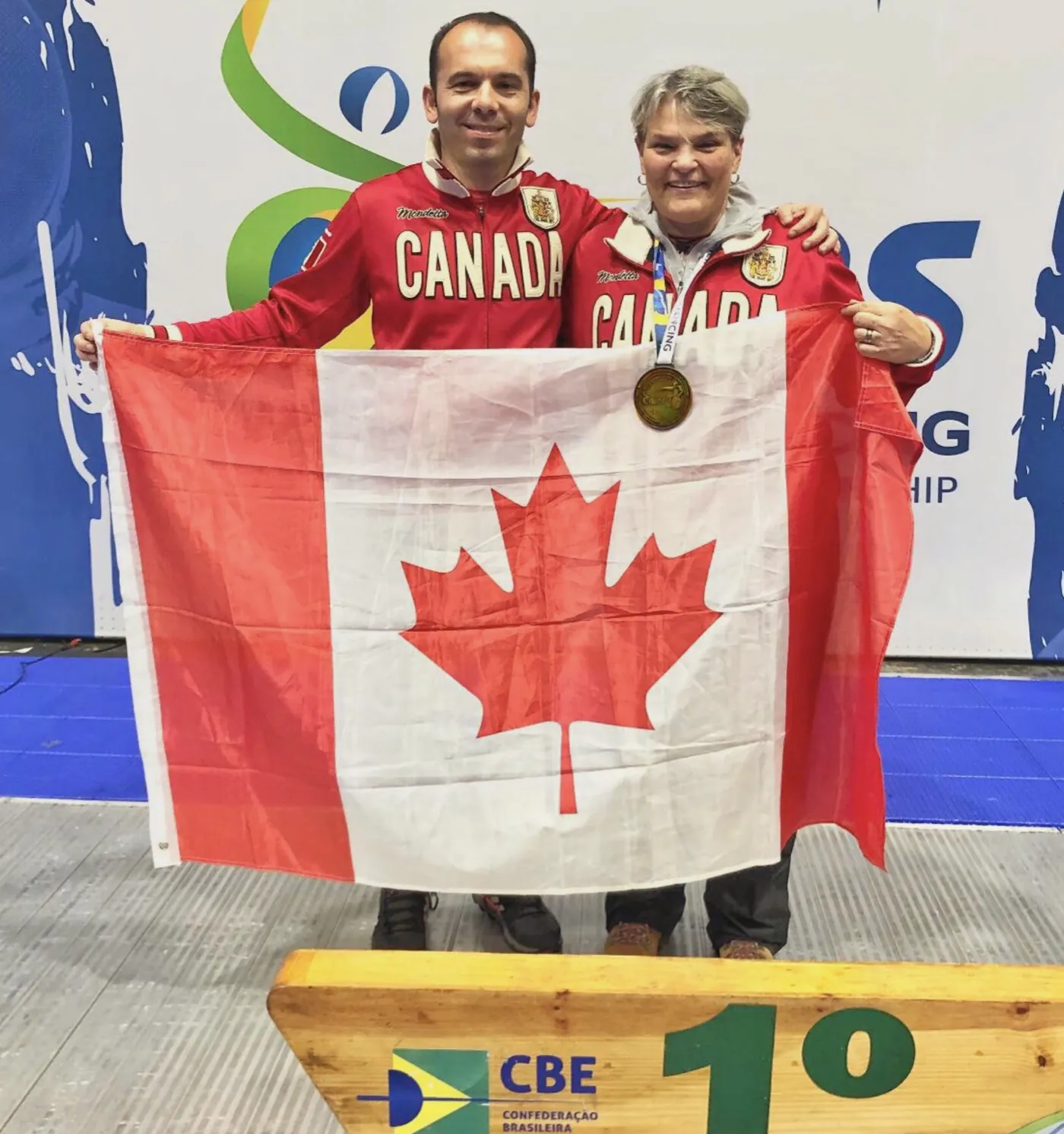 Coach Yousef Alaghehband with Paralympian Sylvie Morel on the podium in Brazil